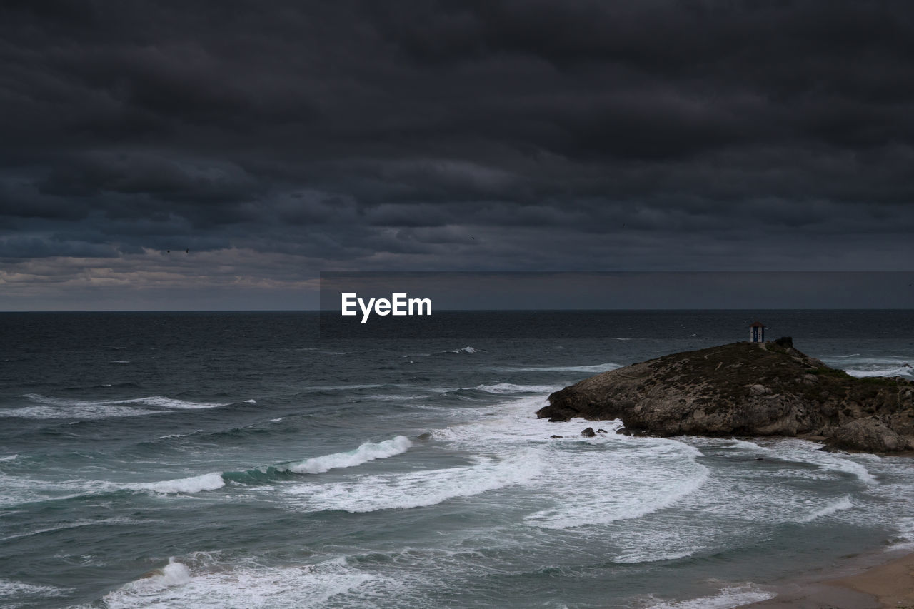 Scenic view of sea against storm clouds