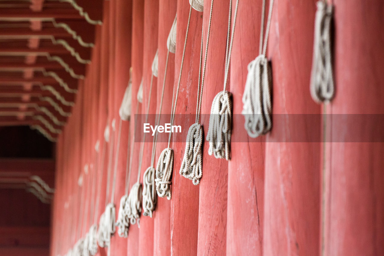 CLOSE-UP OF CLOTHES HANGING ON WOOD AGAINST WALL