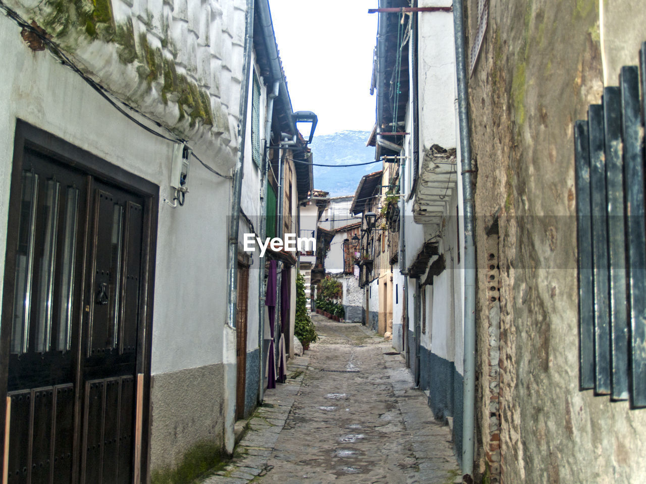 Alley amidst buildings against sky