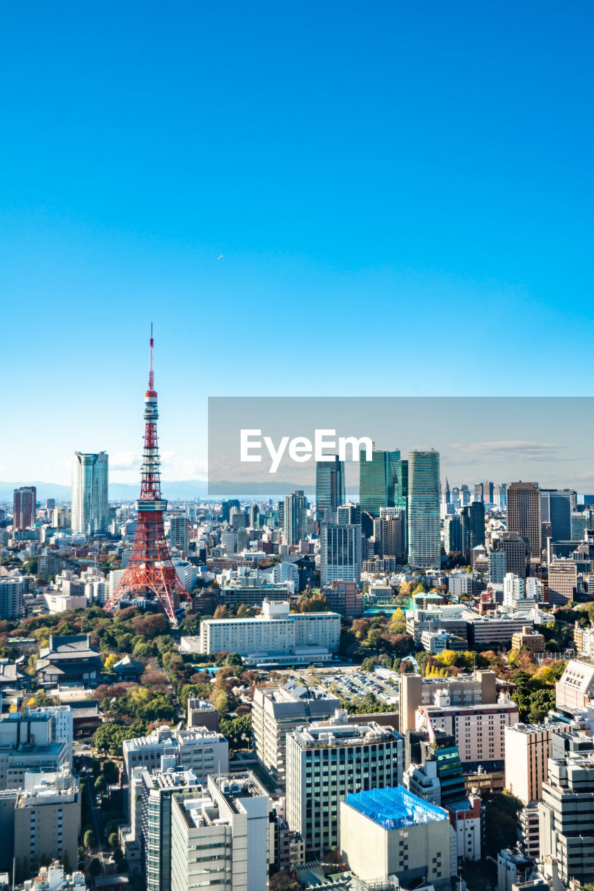 Aerial view of city buildings against blue sky