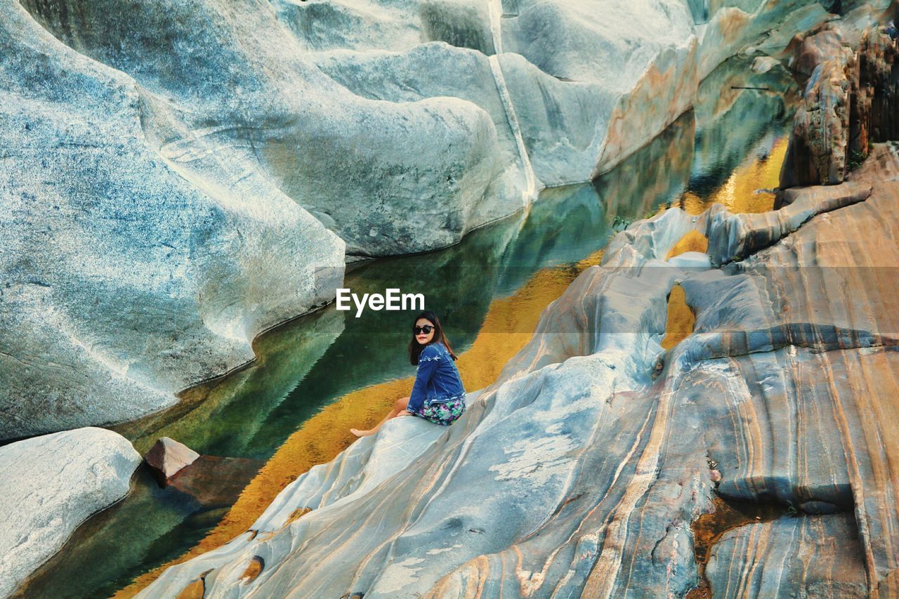 High angle view of woman sitting on rock formation