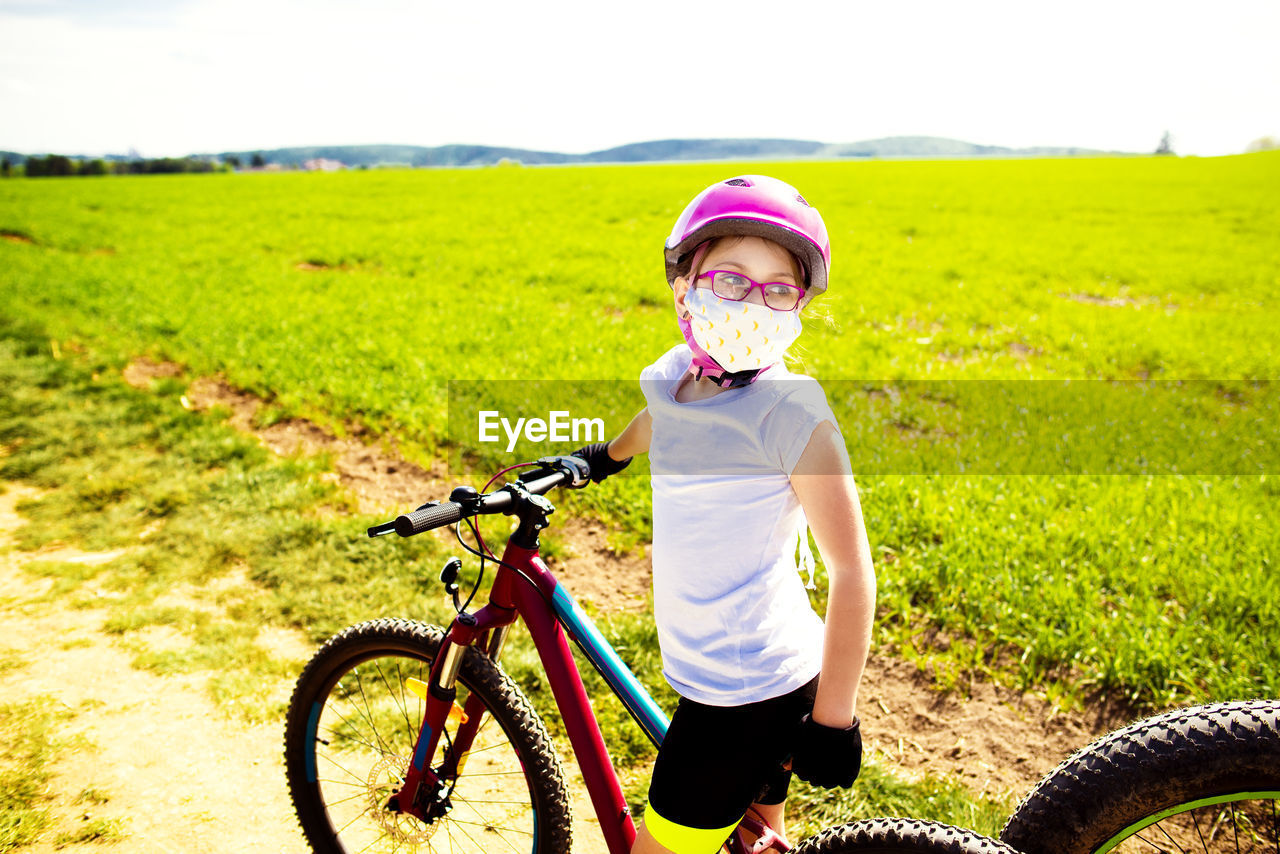 Girl riding bicycle on field