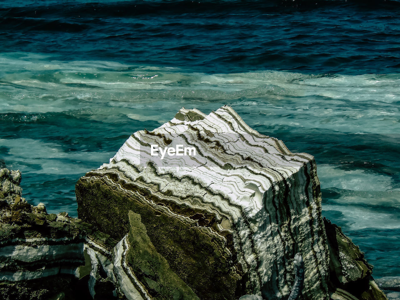 Rock formation on beach against sky