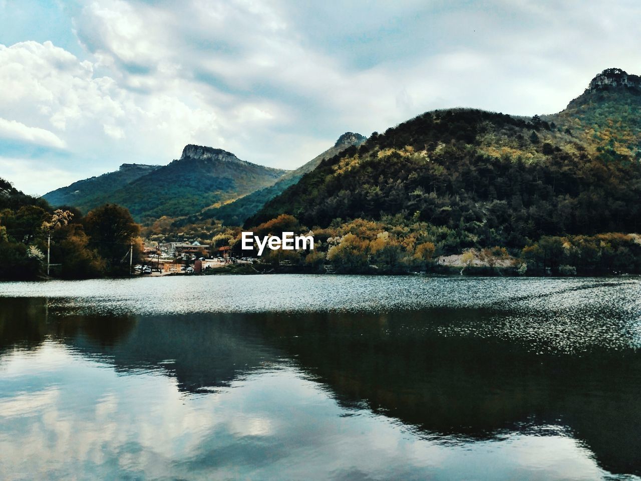 Scenic view of lake by mountains against sky