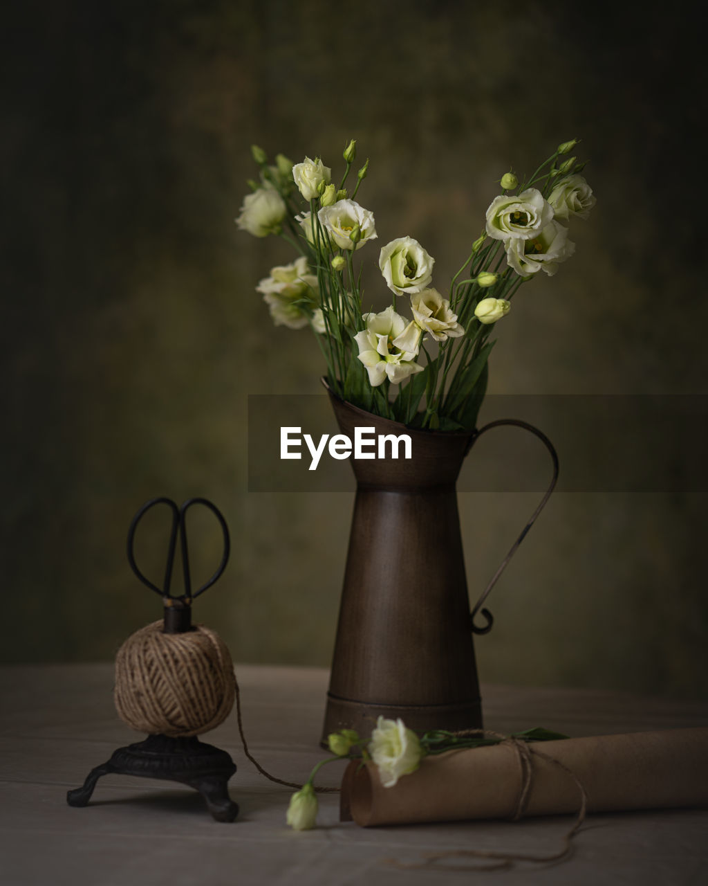 CLOSE-UP OF FLOWER VASE ON TABLE AGAINST WALL
