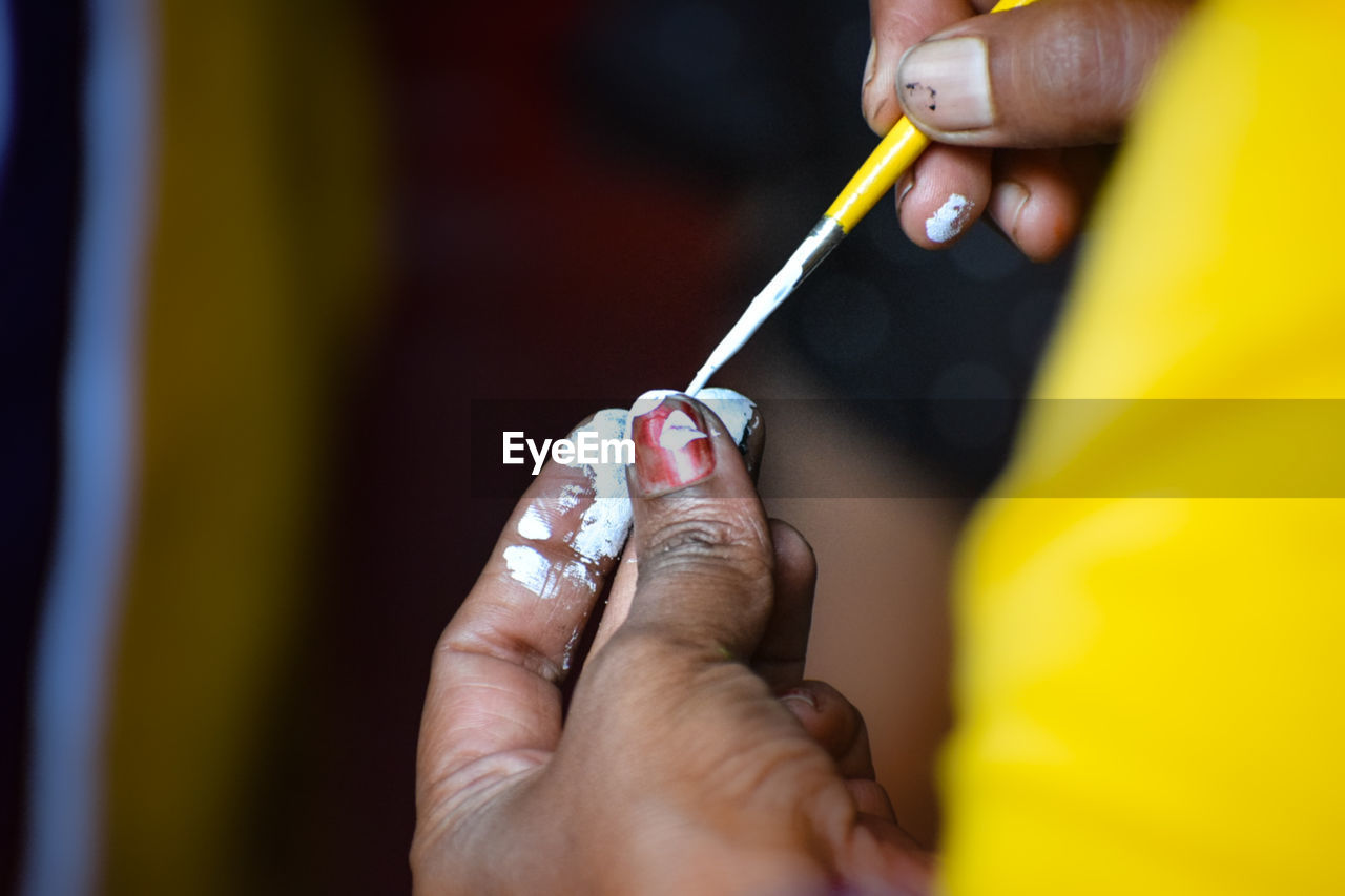 cropped hand of woman applying make-up