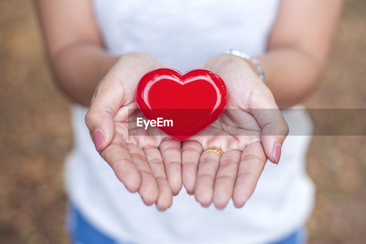 Close-up of woman holding red heart shape