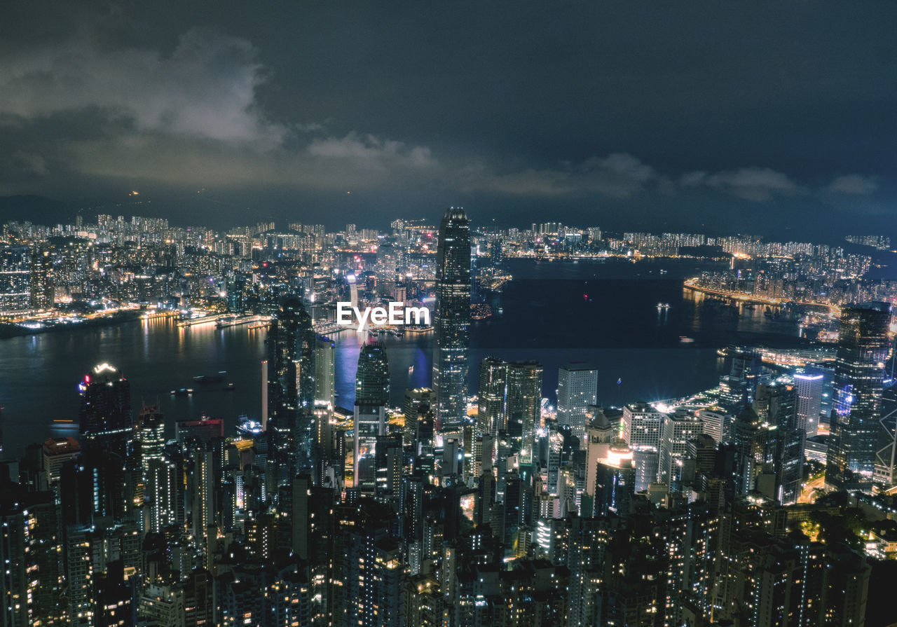 Aerial view of illuminated buildings against sky in city at night
