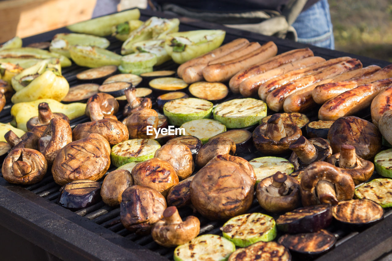 Assorted delicious grilled meats with vegetables over the barbecue on the charcoal. 