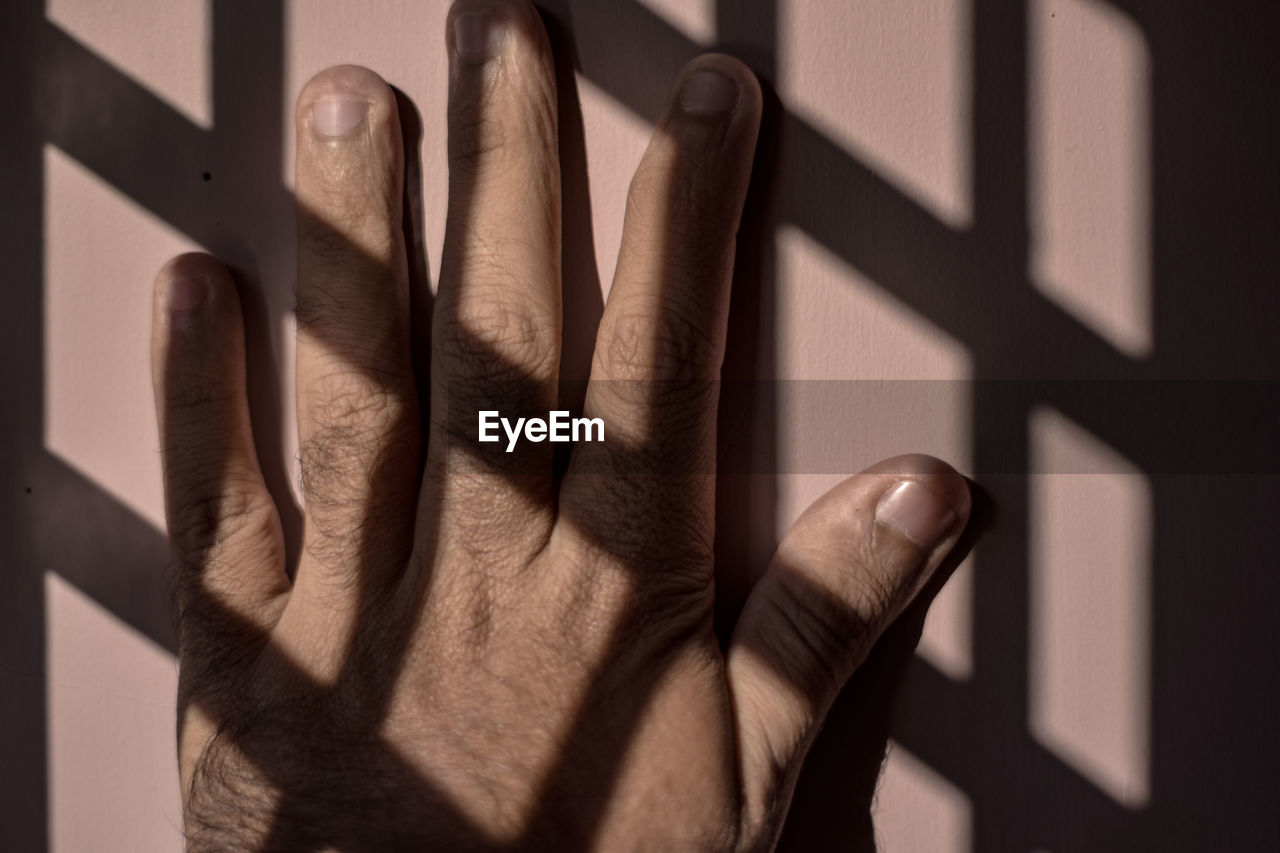 Close-up of human hand on wall