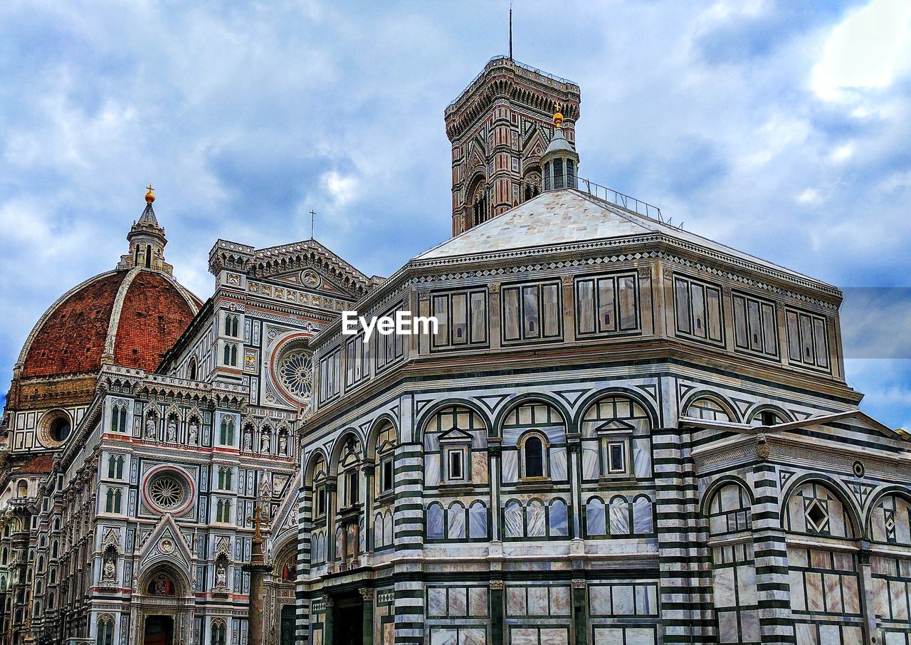 Low angle view of florence cathedral against cloudy sky in city