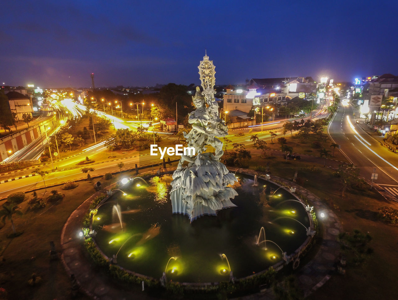 ILLUMINATED FOUNTAIN IN CITY AT NIGHT