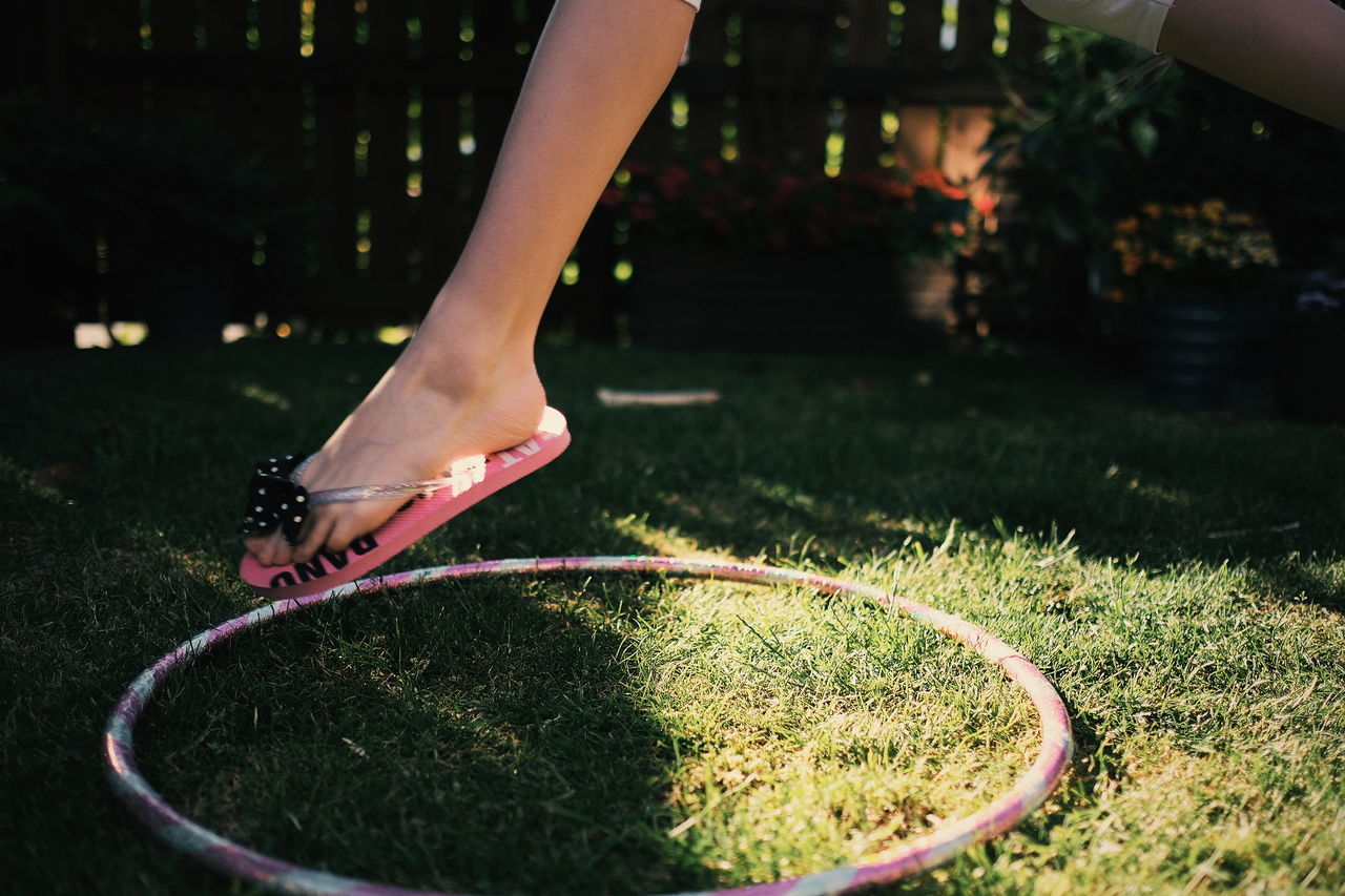 LOW SECTION OF WOMAN STANDING BY LAWN