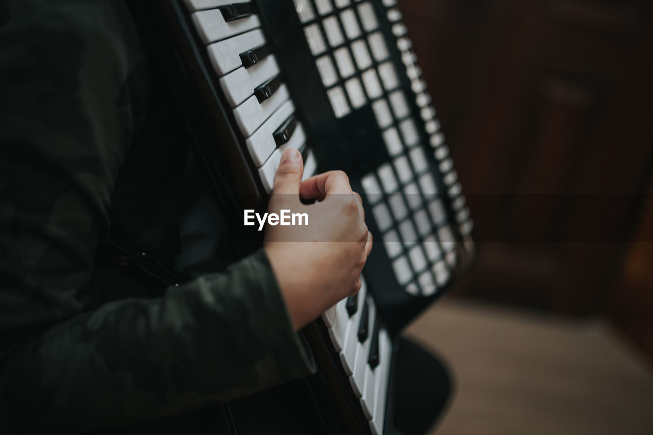 Midsection of man playing accordion