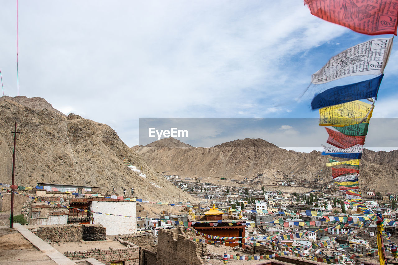 PANORAMIC SHOT OF MULTI COLORED BUILDINGS AGAINST MOUNTAINS