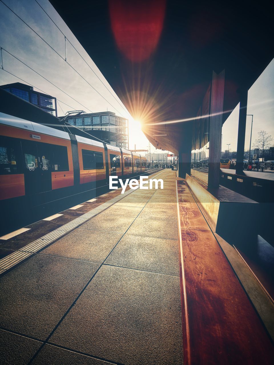 TRAIN AT RAILROAD STATION PLATFORM IN CITY