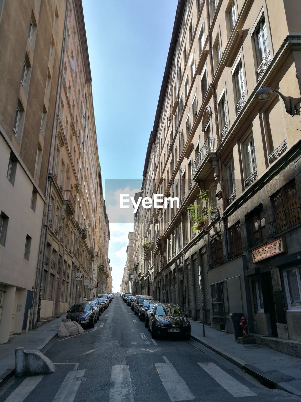 STREET AMIDST BUILDINGS AGAINST SKY