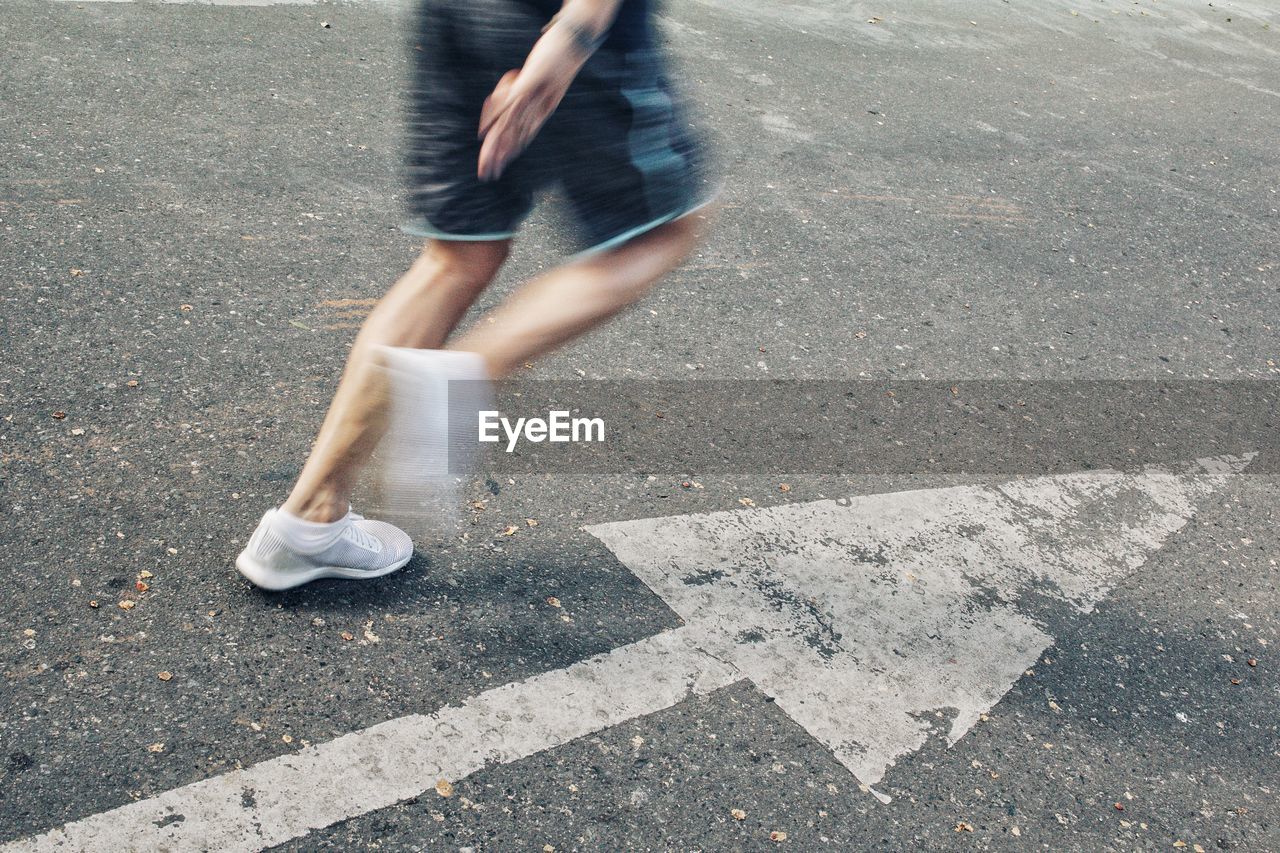 Low section of man running on road