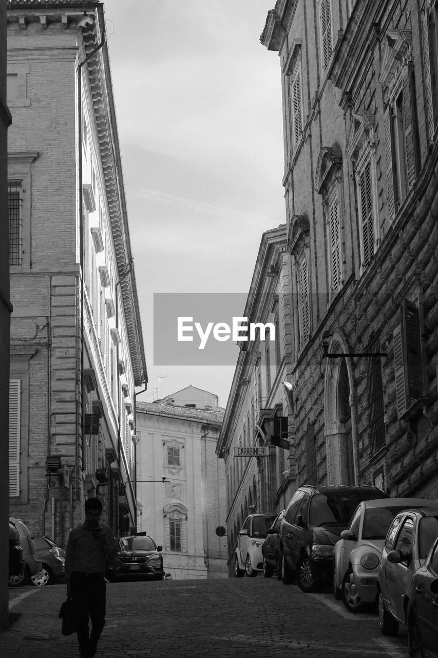 Man walking on street amidst buildings