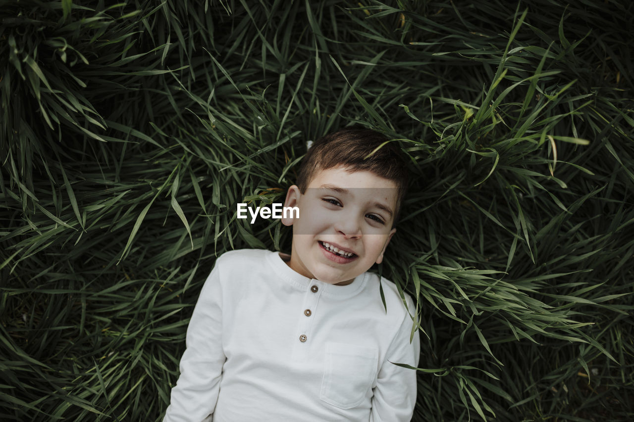 Boy smiling while lying on grass