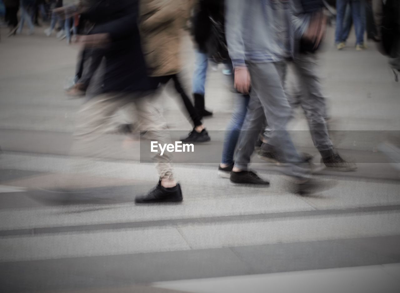 Low section of people walking on street