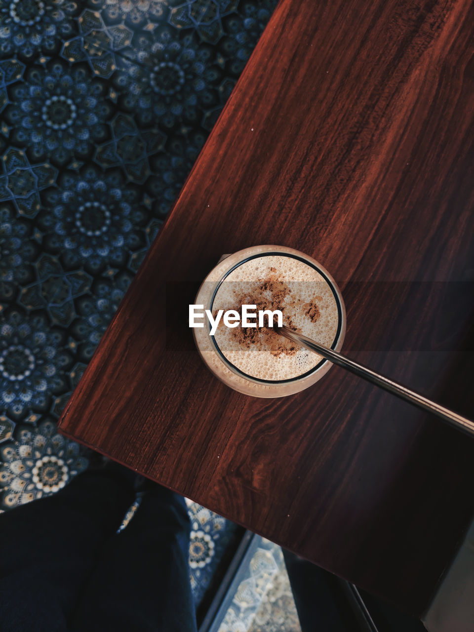 Cropped image of man holding coffee on table