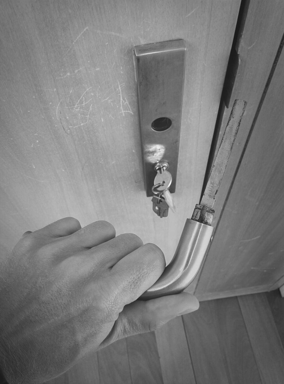 Cropped image of man holding broken door handle