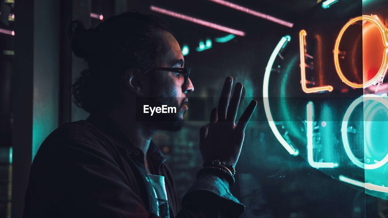 Close-up of thoughtful man looking through window at night