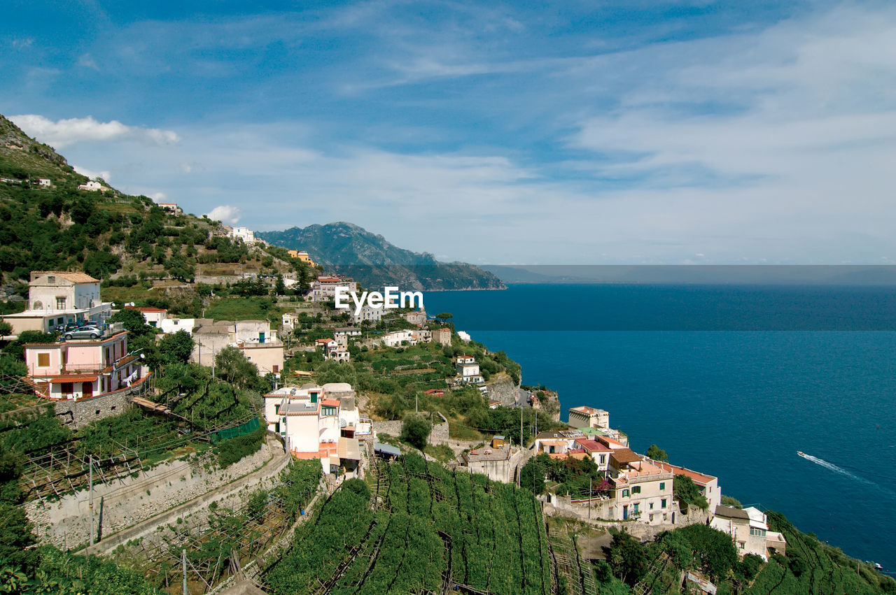 High angle view of townscape by sea against sky