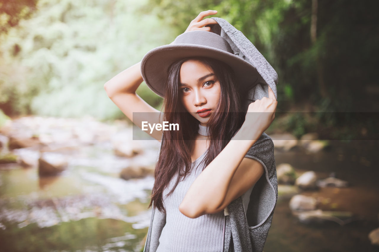 Portrait of young woman by river