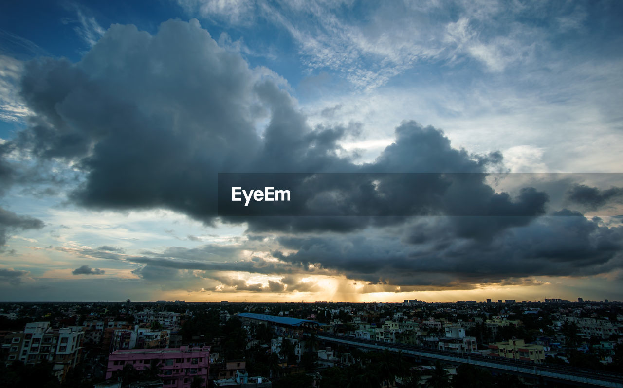 AERIAL VIEW OF ILLUMINATED CITYSCAPE AGAINST SKY DURING SUNSET