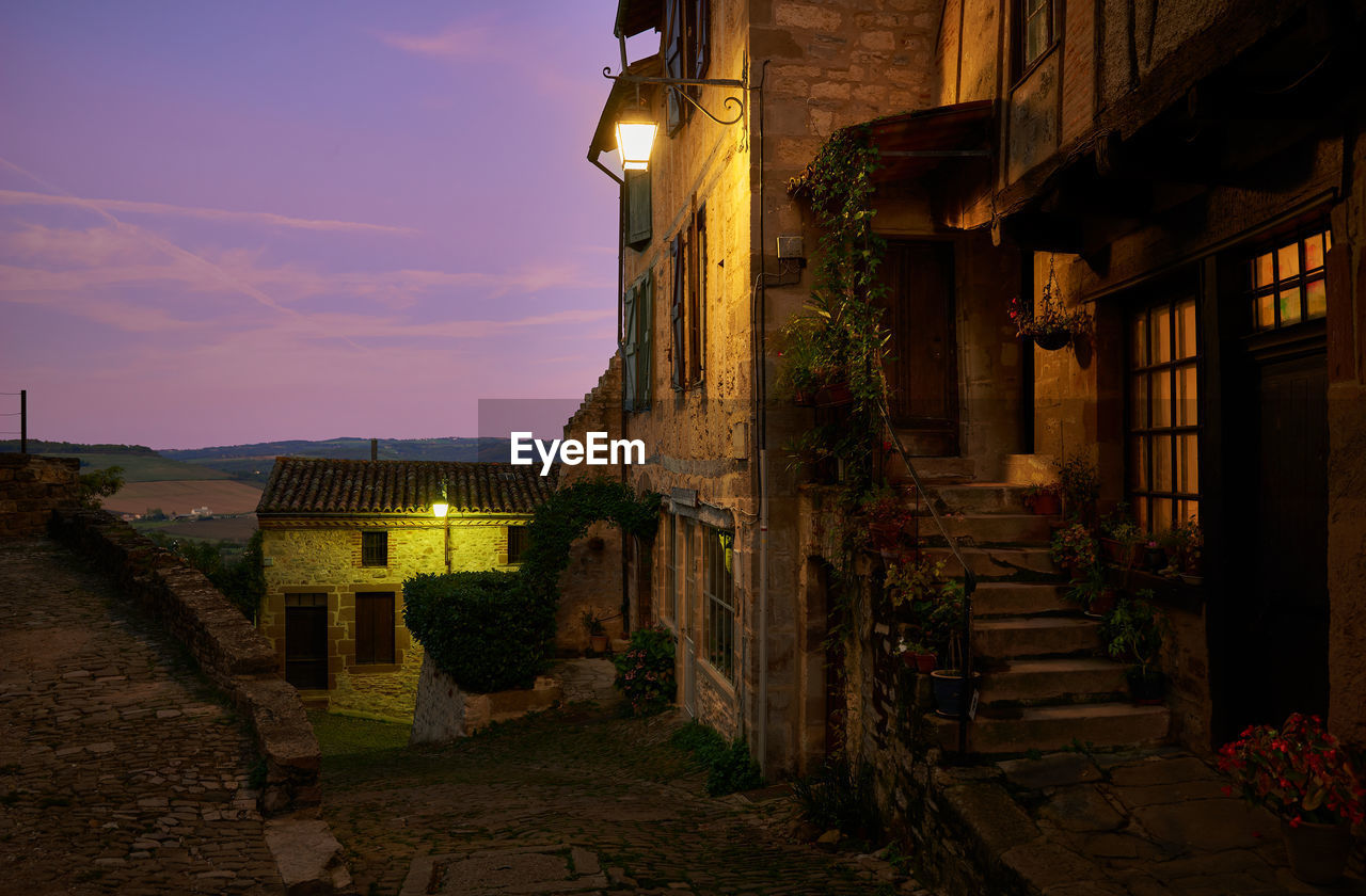 Alley amidst buildings in city at night