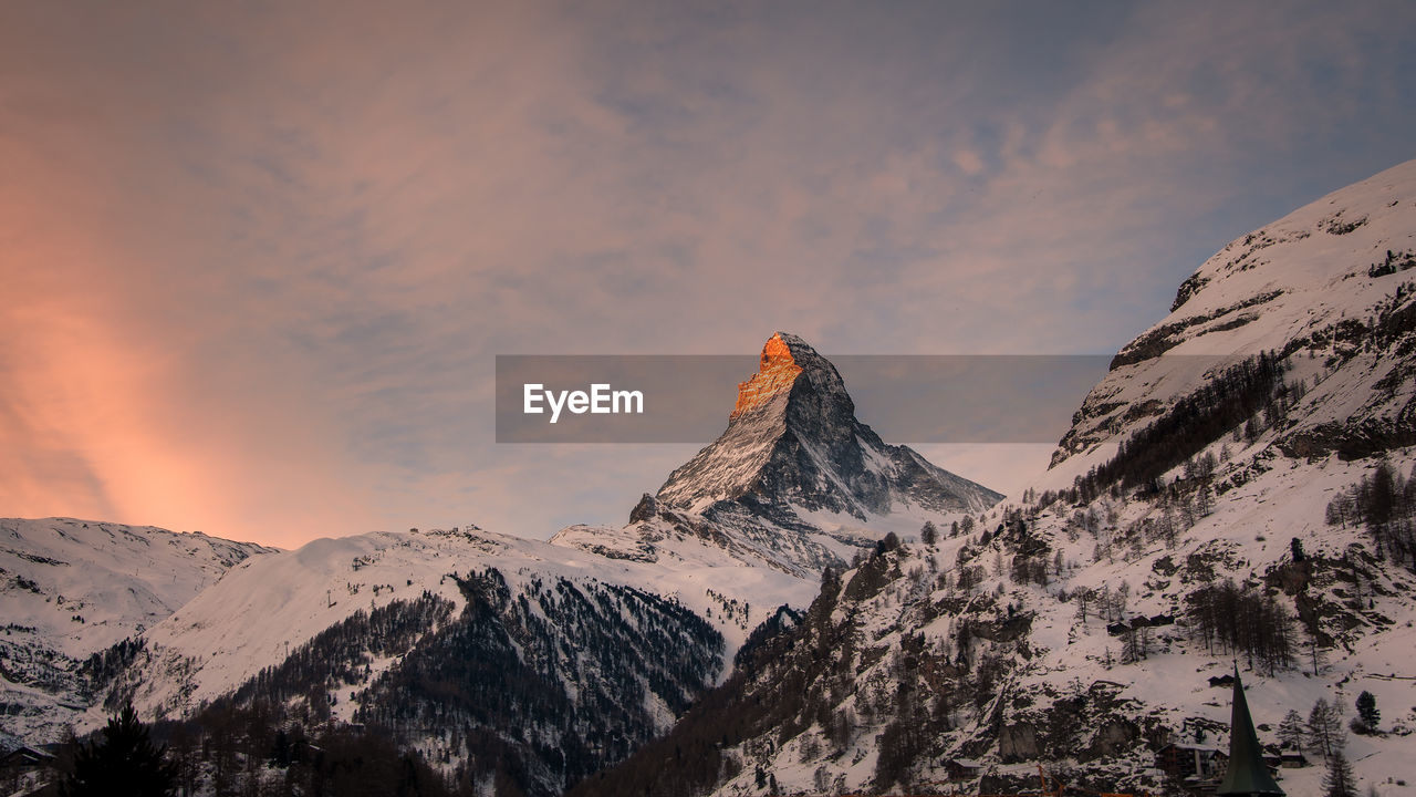 Scenic view of snowcapped mountains against sky during sunset