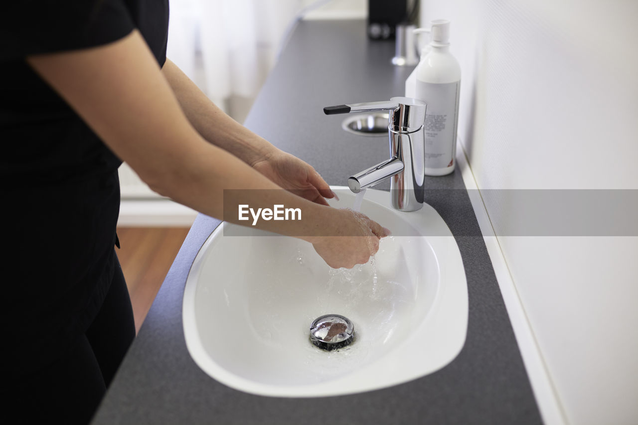 Mid section of woman washing hands