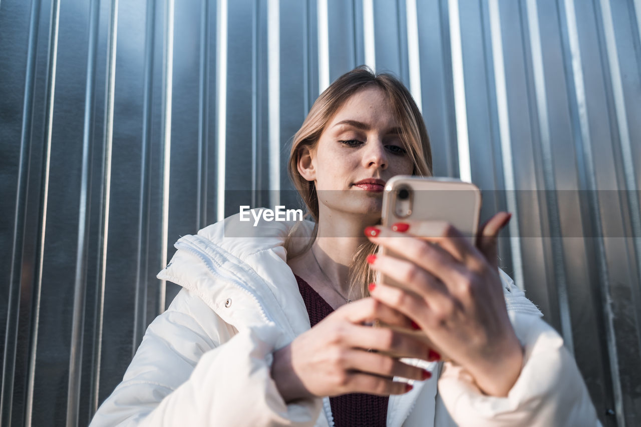 A pretty girl looks into a smartphone and takes a selfie. high quality photo
