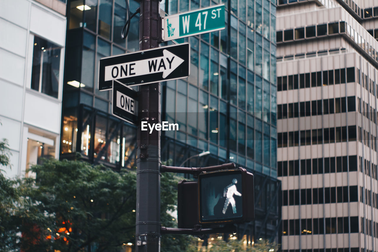 Low angle view of road sign against buildings in city