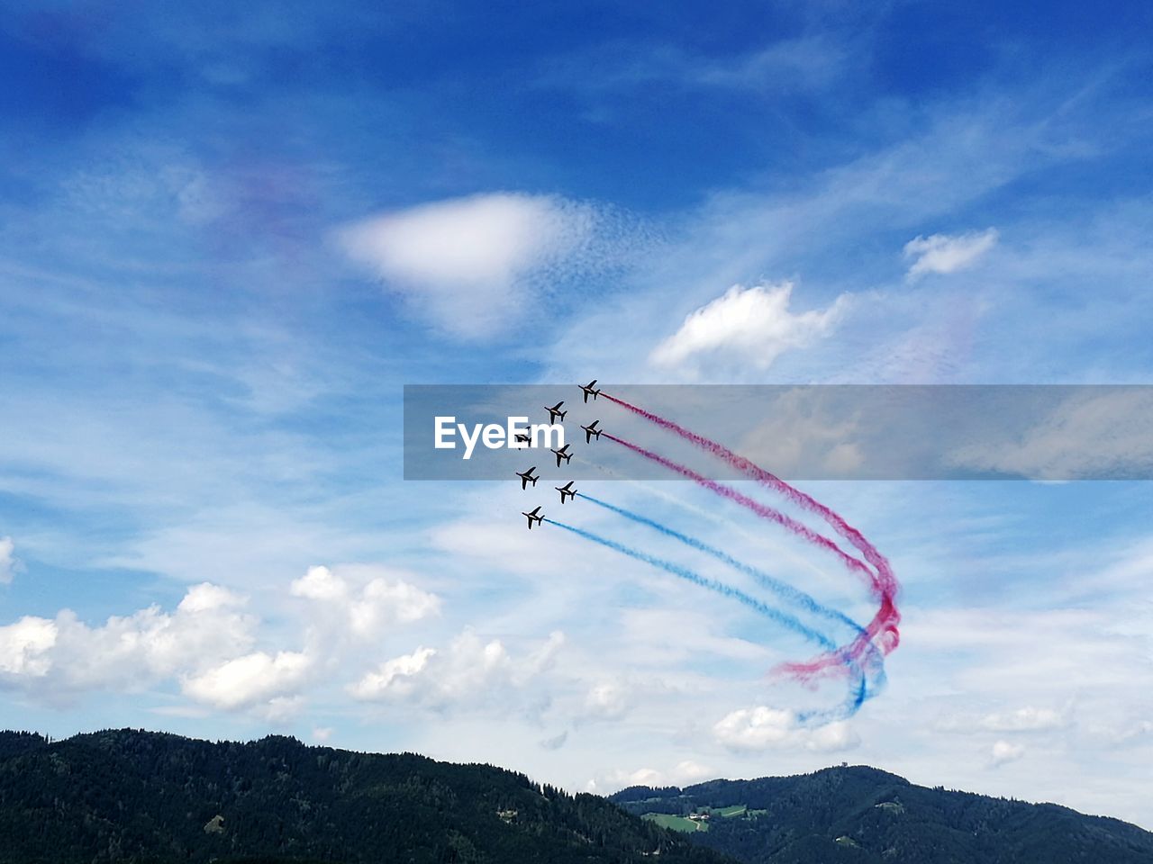 LOW ANGLE VIEW OF PARACHUTE FLYING OVER LANDSCAPE