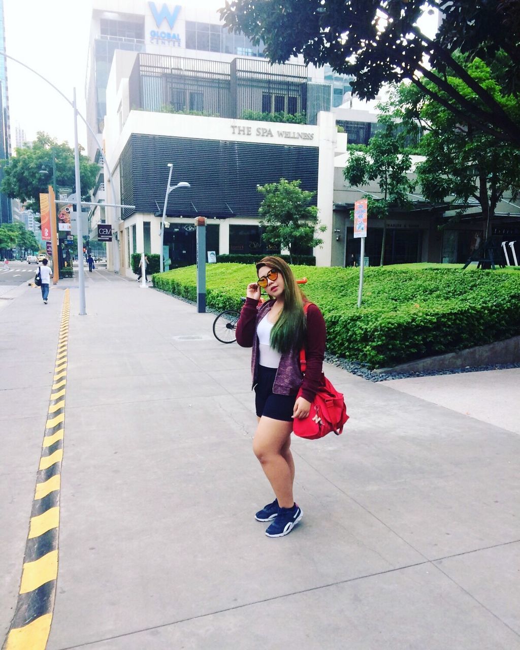 FULL LENGTH OF YOUNG WOMAN USING MOBILE PHONE WHILE STANDING OUTDOORS