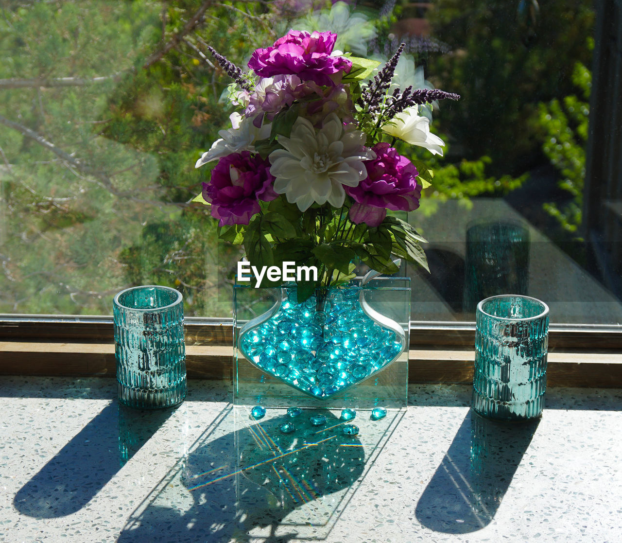 CLOSE-UP OF FLOWER POT ON TABLE AGAINST GLASS