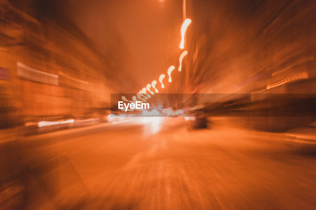 BLURRED MOTION OF ILLUMINATED ROAD AT NIGHT