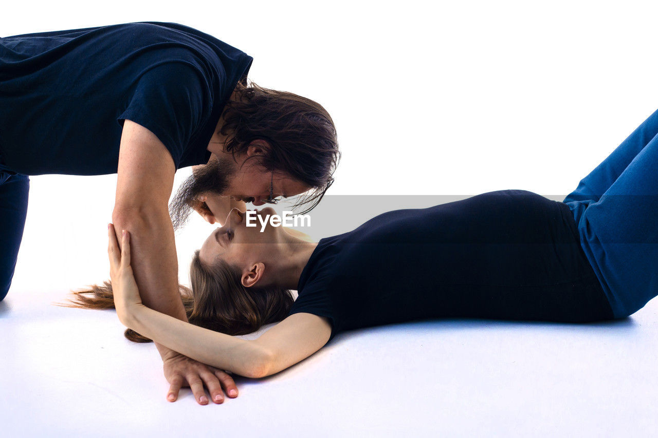 adult, sports, lifestyles, indoors, women, human leg, lying down, young adult, sitting, limb, two people, physical fitness, arm, exercising, men, person, female, relaxation, sports clothing, wellbeing, strength, studio shot, stretching, flexibility, clothing, leisure activity, full length, practicing