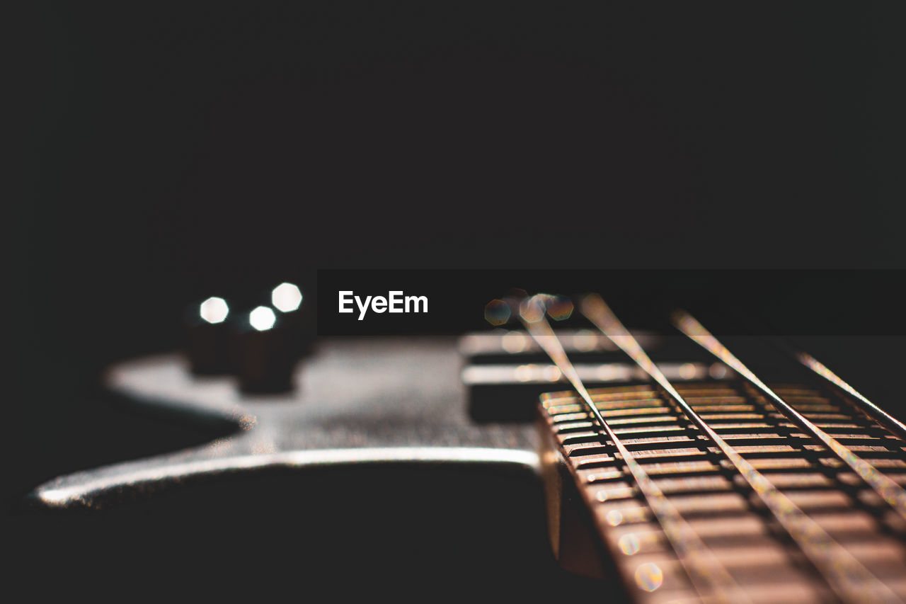 Close-up of guitar against black background