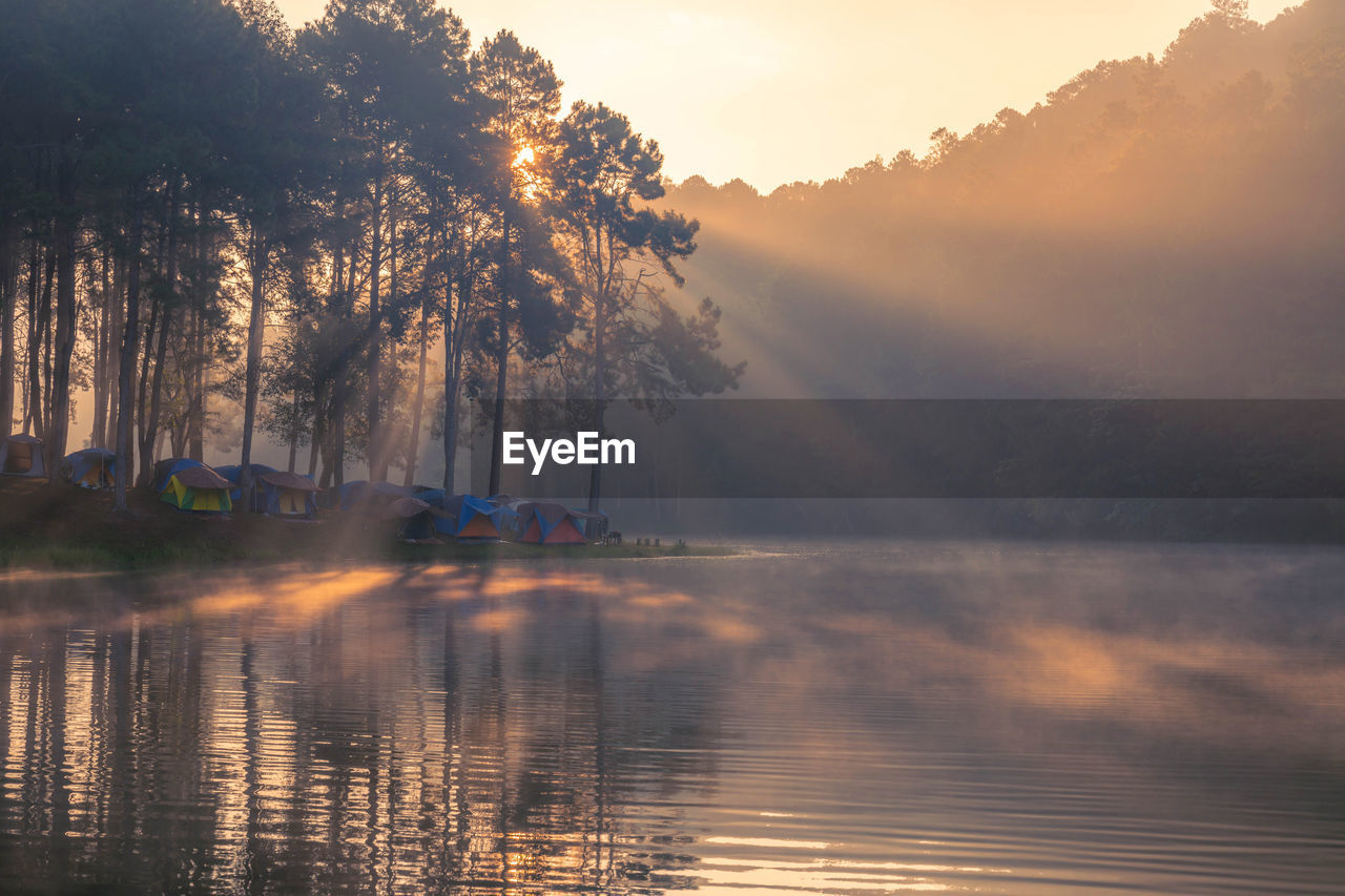 Morning sunrise over stream and pine tree camping in lake at pang ung lake, mae hong son , thailand