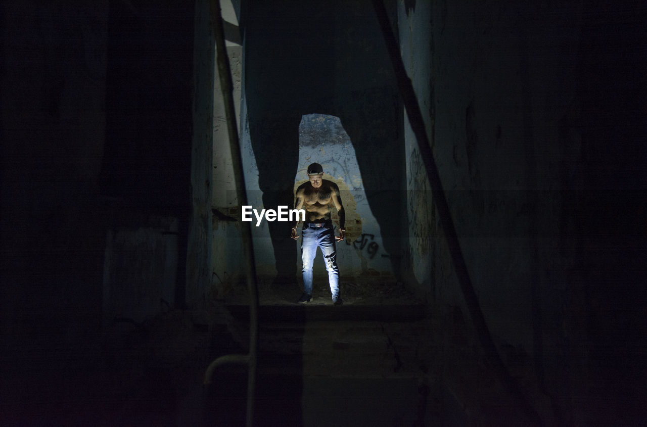 Shirtless man standing in darkroom