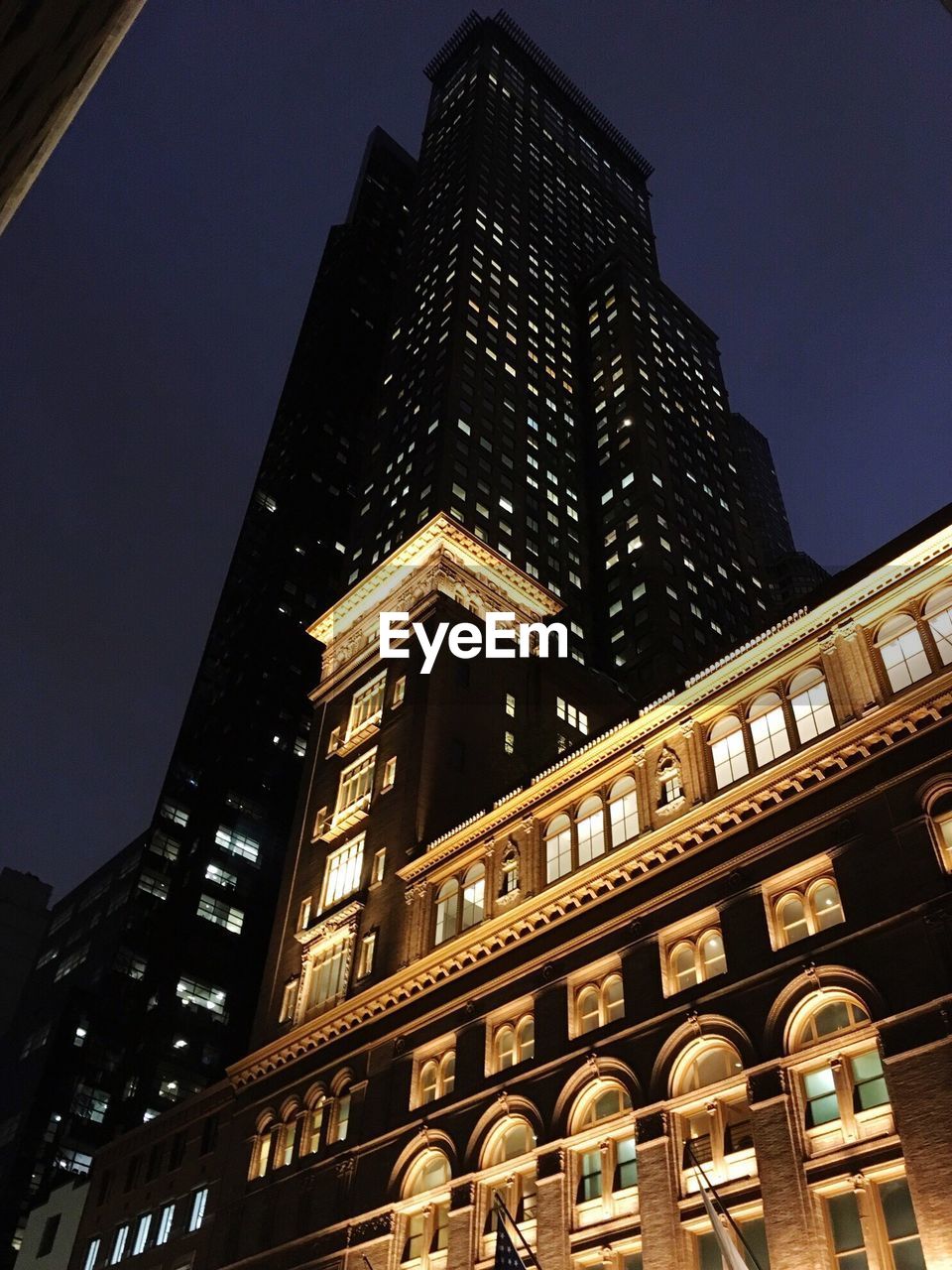 LOW ANGLE VIEW OF BUILDINGS IN CITY AT NIGHT