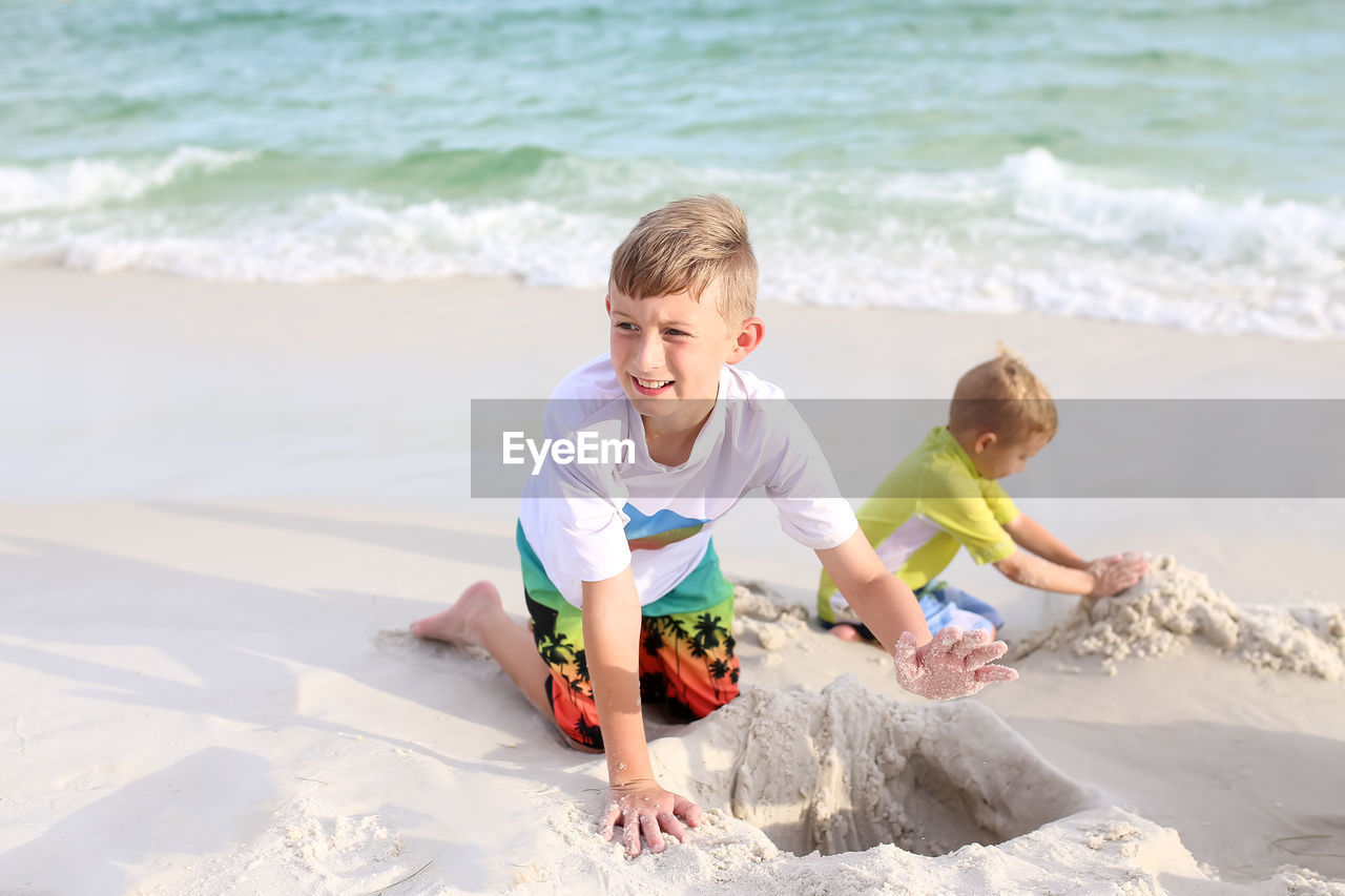 Brothers making sandcastles at beach