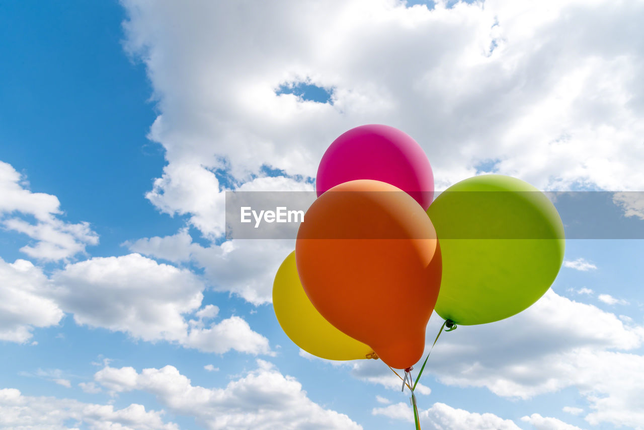 Low angle view of balloons against sky