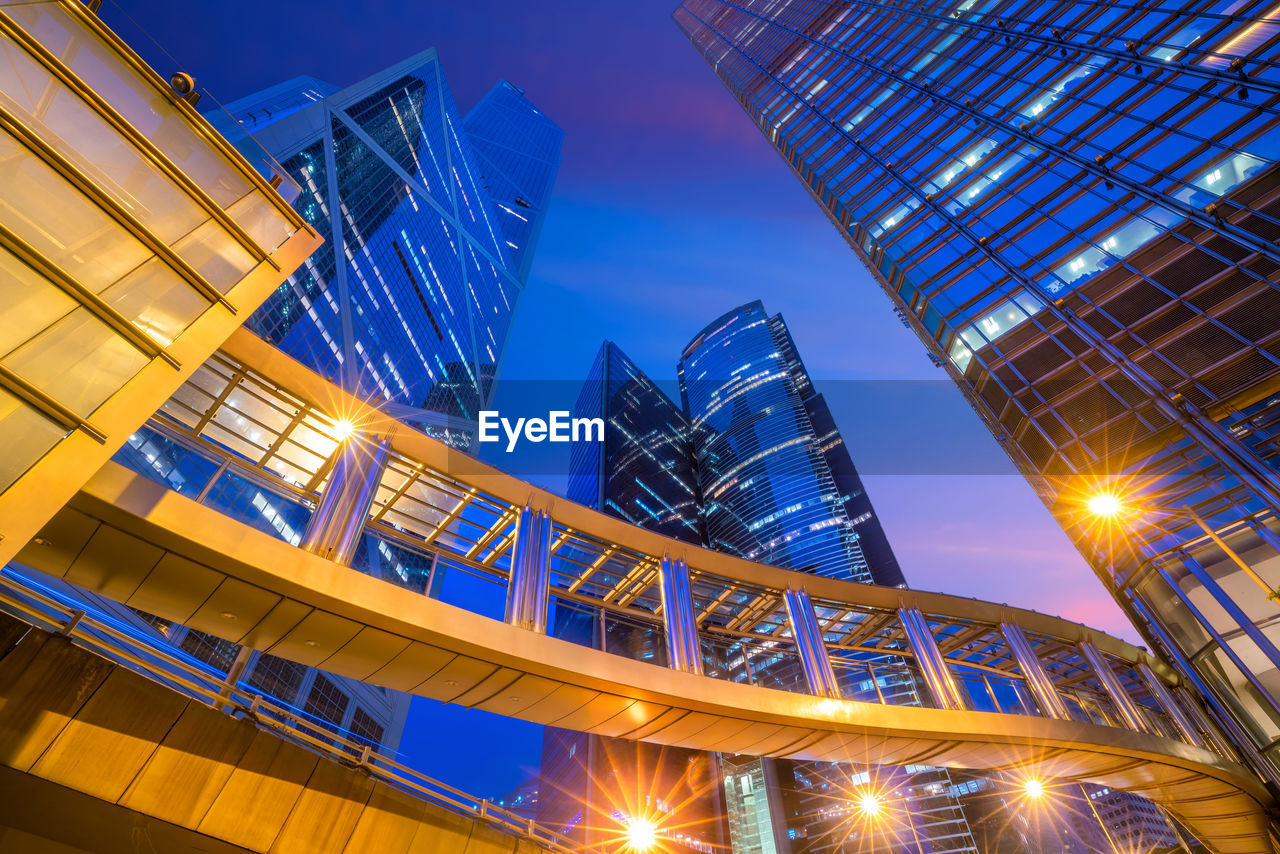 LOW ANGLE VIEW OF ILLUMINATED MODERN BUILDINGS AGAINST SKY AT NIGHT