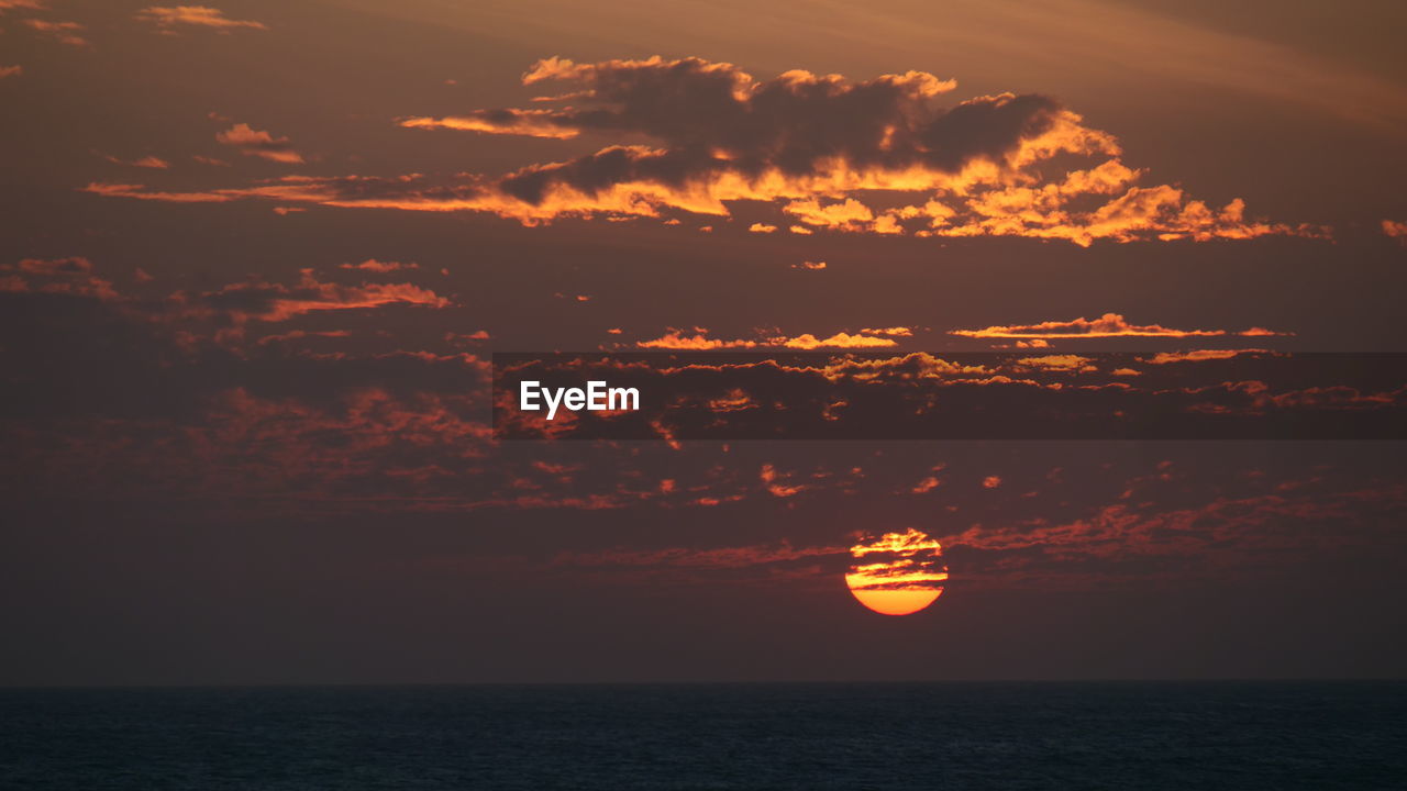 SCENIC VIEW OF SEA AGAINST ORANGE SKY DURING SUNSET