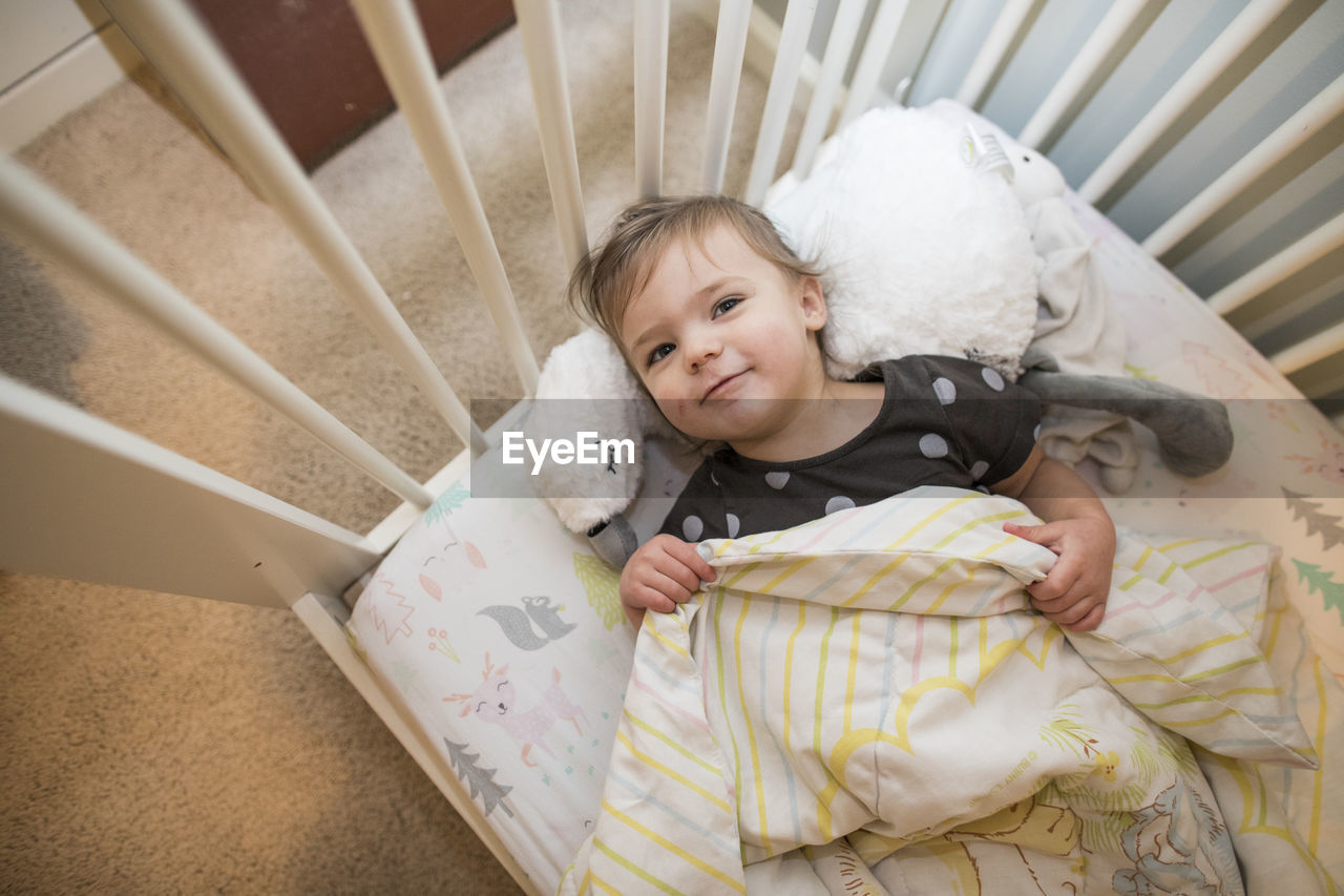 High angle view of toddler girl laying in her bed.